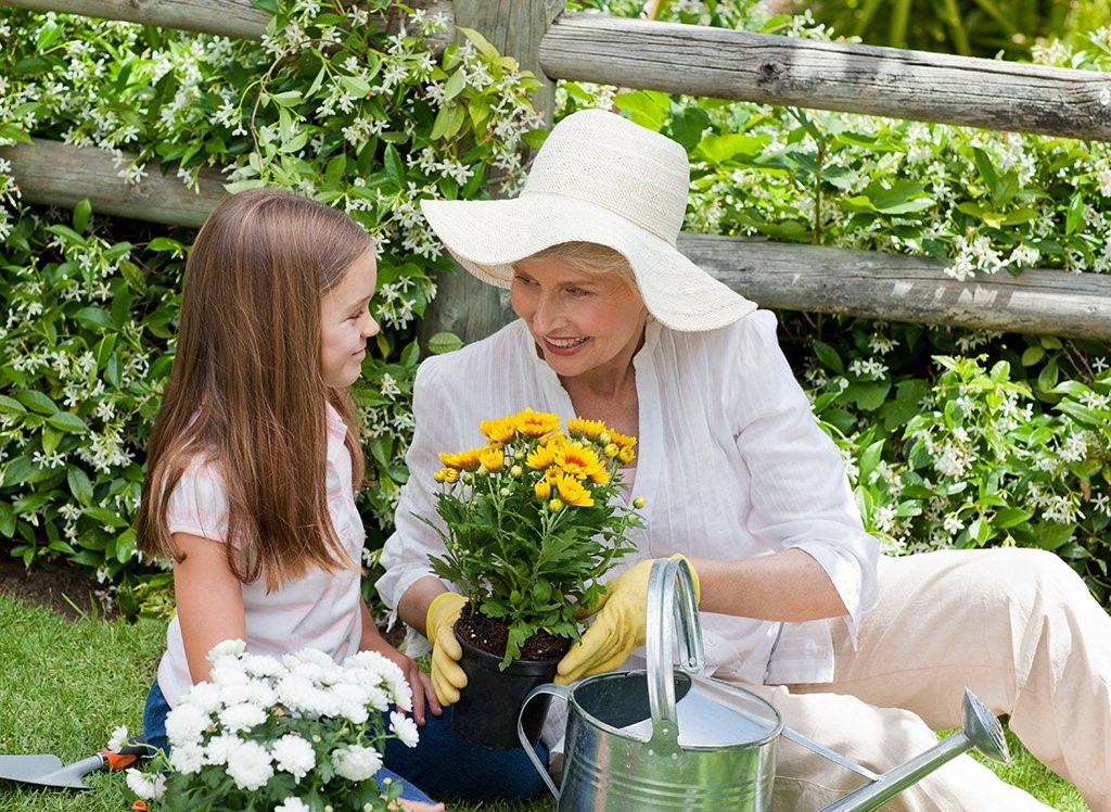 Elderly woman playing and gardening with her granddaughter